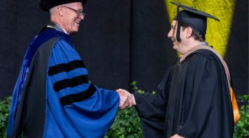 Pictured: Ralph Owen Dean Tom Steenburgh shakes hands with 2025 Vanderbilt Business Commencement Speaker Jeremy Padawer