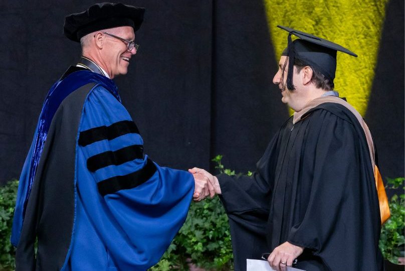 Pictured: Ralph Owen Dean Tom Steenburgh shakes hands with 2025 Vanderbilt Business Commencement Speaker Jeremy Padawer