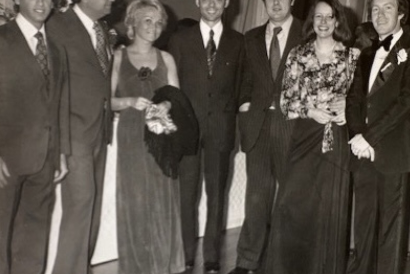 Pictured: An old photo featuring a group of people in dress attire. Philipe Gluntz, Vanderbilt Business alum, is shown with his wife.
