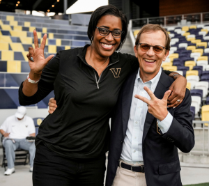Pictured: Vanderbilt Business alumnus John Ingram with Candice Storey Lee doing the VU hand sign.