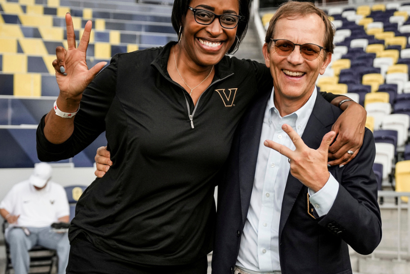 Pictured: Vanderbilt Business alumnus John Ingram with Candice Storey Lee doing the VU hand sign.