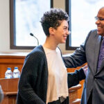 Houston Baker laughs with a student at an event in a meeting room