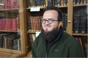 smiling man in front of bookcase