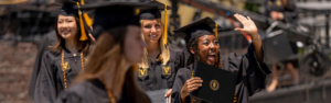 Vanderbilt students in caps and gowns holding diplomas