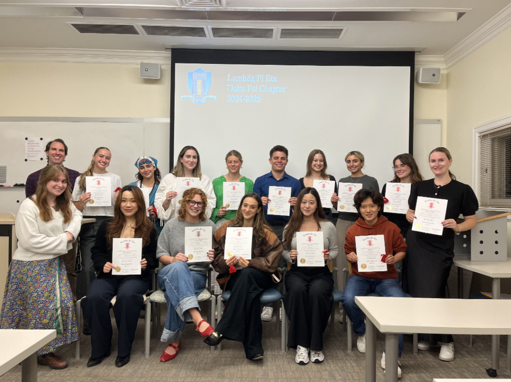 Students holding up their honors society certificates