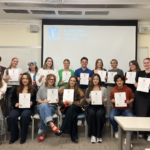 Students holding up their honors society certificates