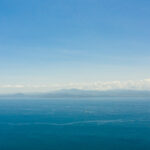 Blue sea and the tropical island of Basilan with mountains. Seascape with a tropical island. Zamboanga, Mindanao, Philippines.