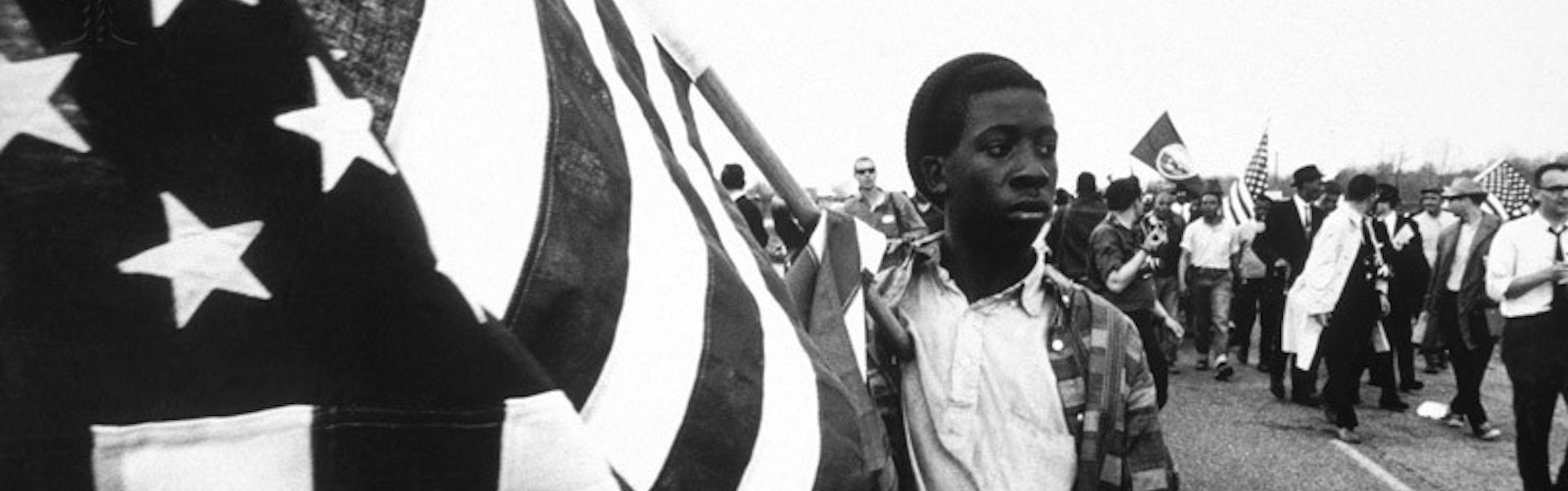 young man marching with american flag