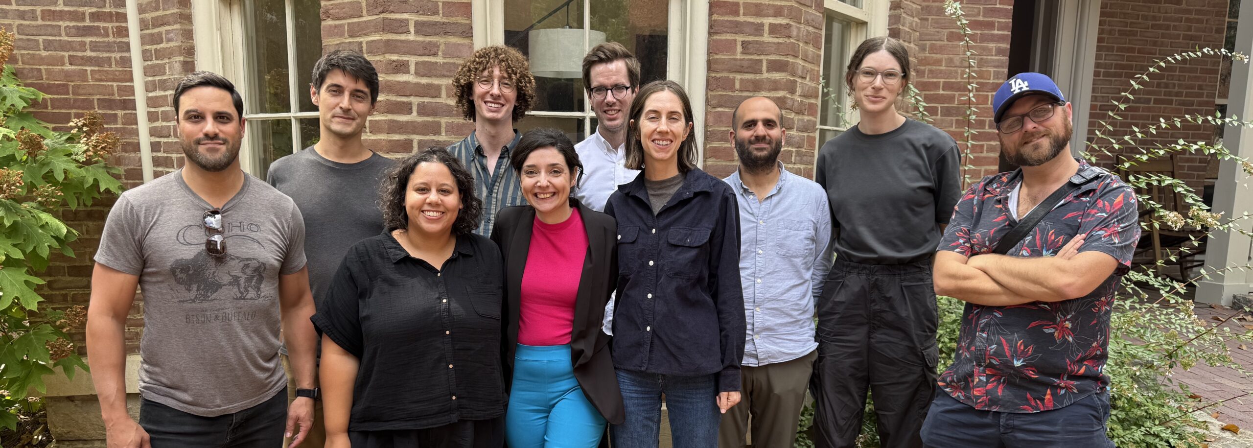 Group of students standing in front of brick house