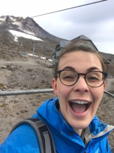 Elizabeth Teeter smiles excitedly on the side of a mountain