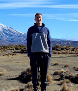 Bryce Belanger standing in front of a mountain
