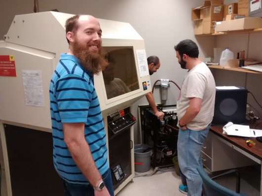 Graduate Student Evan Robinson looks on as the old X-Ray Diffractometer is decommissioned by Postdoctoral Fellow Dr. Emil Hernandez and Graduate Student Andrew La Croix. Evan isn’t too sad to see the old beast go, and is pretty excited about the new XRD and how much faster his experiments will be.