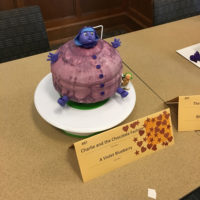 A cake made to look like Violet Beauregarde as a blueberry.