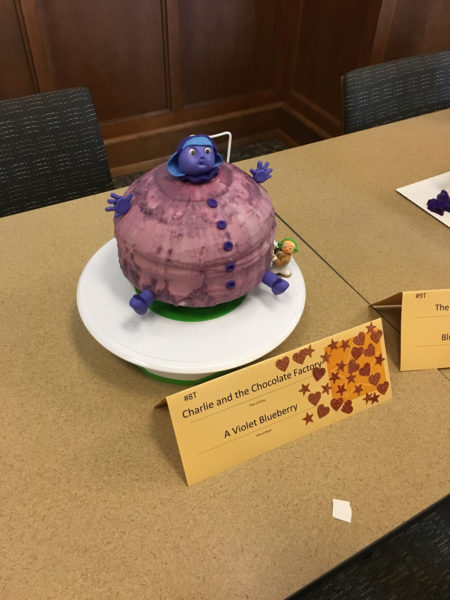 A cake made to look like Violet Beauregarde as a blueberry.