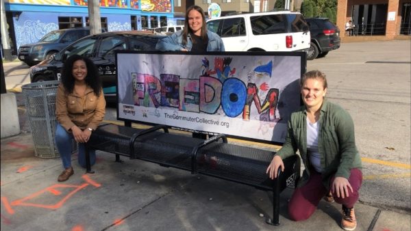 Vanderbilt Divinity School students admire children's art on Nashville bus bench