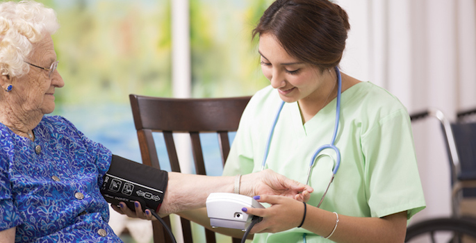 nurse checks elderly woman's blood pressure
