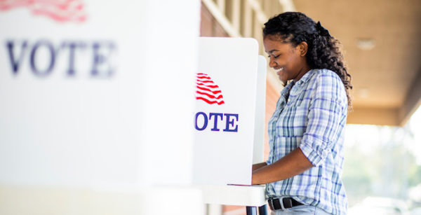 A young black woman voting on election day