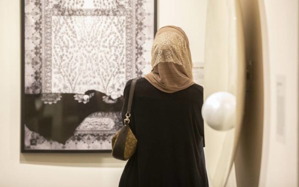 An attendee of the 'I AM' opening reception views a piece of art in the Vanderbilt Fine Arts Gallery.