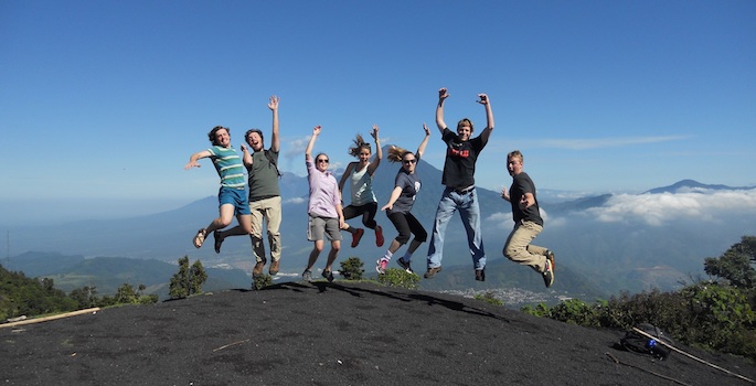 students jumping in the air on top of volcano
