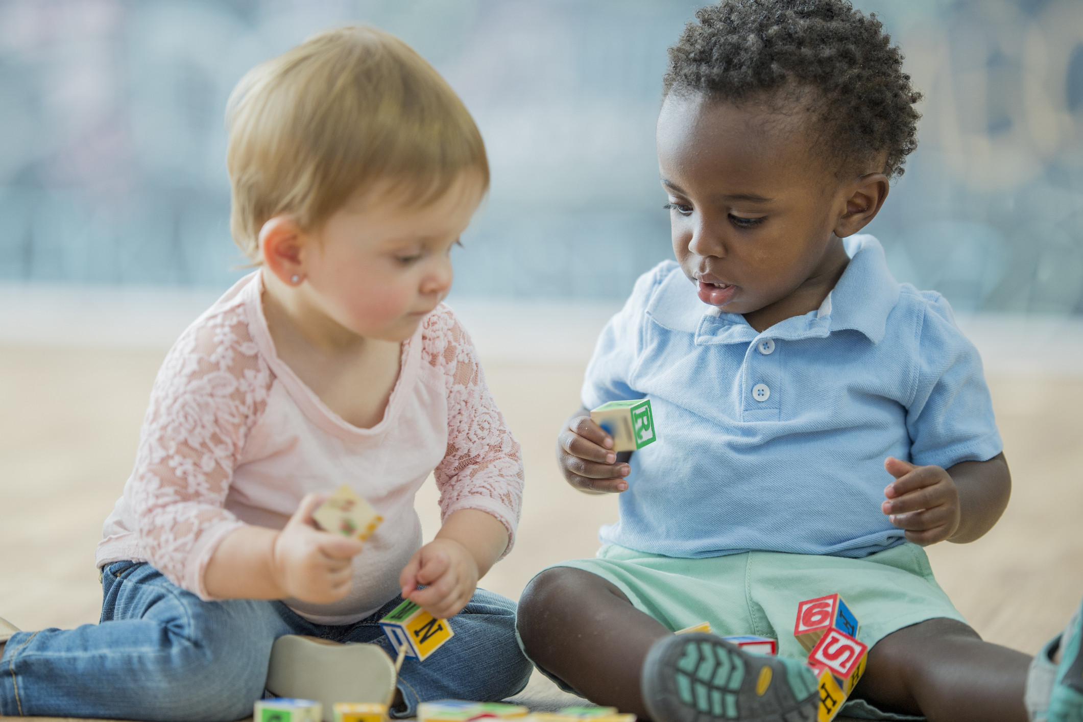 two babies playing with blocks