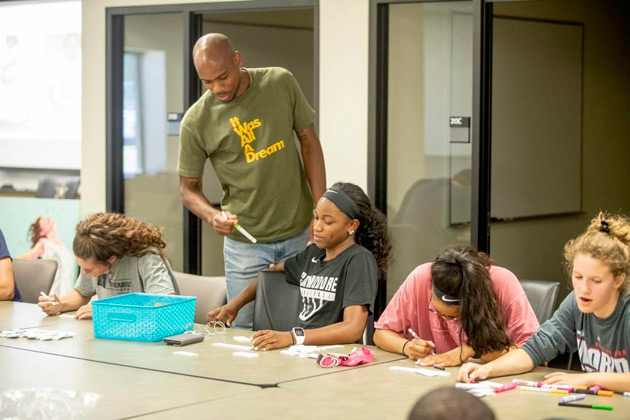 During a workshop organized by the Curb Center, Nashville artist Omari Booker mentors first-year student-athletes for a collaborative art project. (John Russell/Vanderbilt)