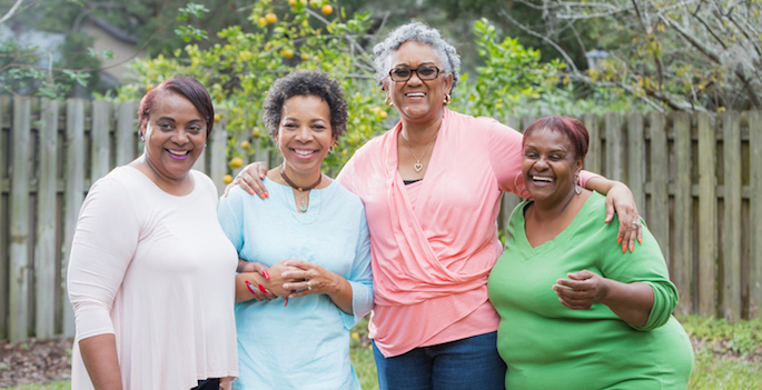 four african american women posing for a photo outside. some are overweight.