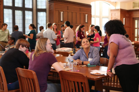 diverse postdocs gathering in Alumni Hall for delicious pizza