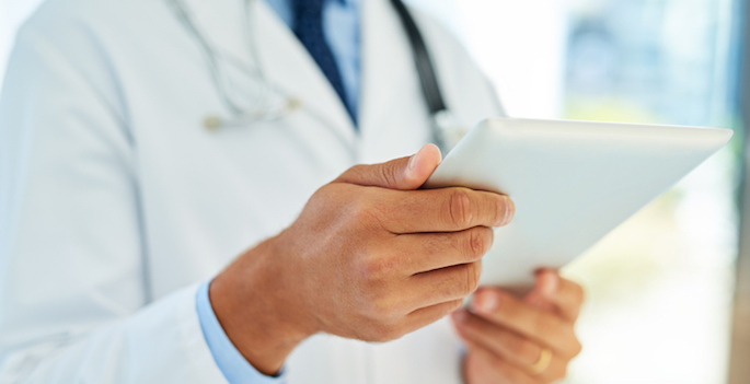 close up of male doctor looking at ipad