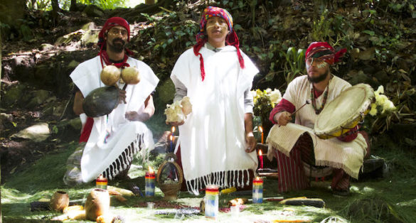 Three men in traditional Maya dress