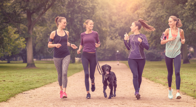 Four slender young white women jogging in the park
