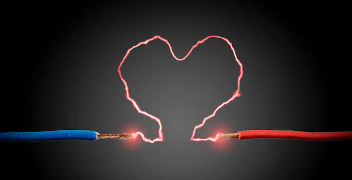 electricity arcing in a heart shape between two exposed wires