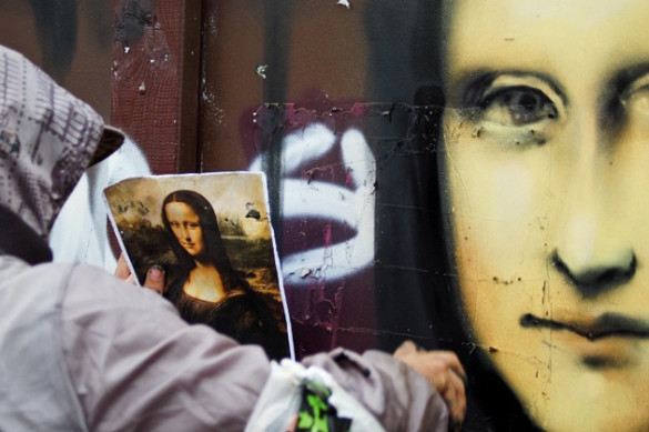 Vilnius, Lithuania - Sept. 6, 2011: Graffiti artist drawing Mona Lisa on a wall while looking into a picture of actual painting. He is painting it at a Nescafe Street Art event were graffiti artists made legal graffiti painting at a skate park. (iStockphoto)