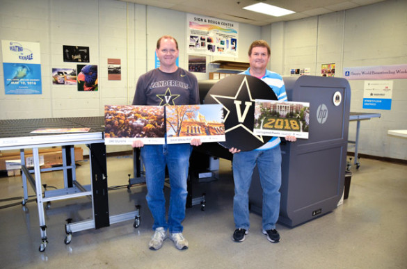 Prepress technician Roger Sauls (left) and prepress supervisor Sam Daugherty display products created using Vanderbilt University Printing Services' new flatbed UV printer.