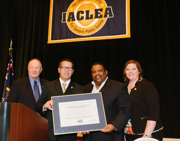 Assistant Chief Rick Burr (second from left) and Chief August Washington (second from right) accept VUPD's reaccreditation certificate at the IACLEA conference.