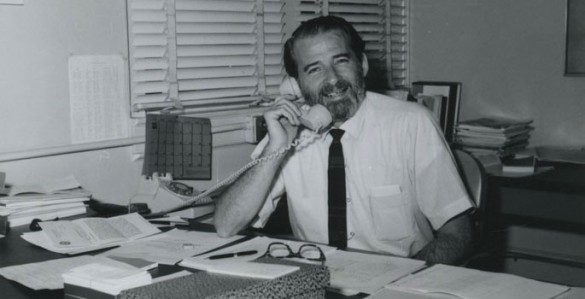 sitting a desk talking on phone