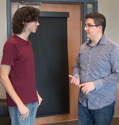 Josua Wade, who has written his doctoral dissertation on the driving simulator, on the right, is talking with study participant Brandon Roberson. (Vanderbilt University)