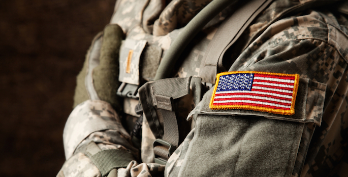 close-up of camouflauge uniform with american flag patch