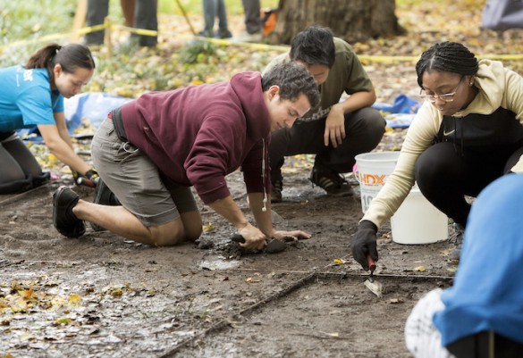 students on hands and knees on wet dirt