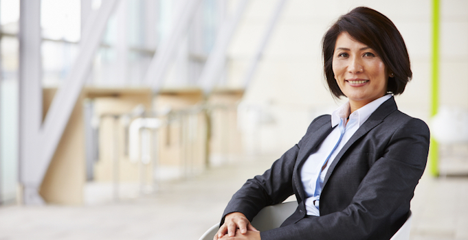 Portrait of smiling Asian businesswoman, sitting