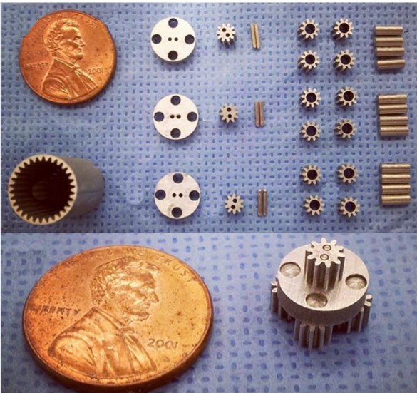 components laid out on table next to a penny for scale