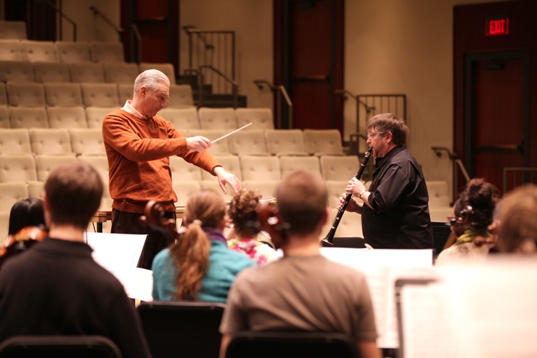 Composer directing clarinetist and other musicians