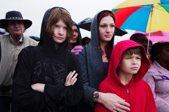 Mother, daughter, and son standing in the rain