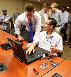 Student at computer speaking to adult