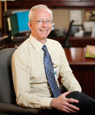 Donald Brady sitting in office 