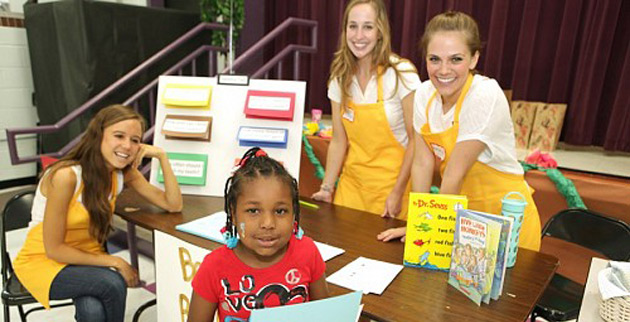 Rising kindergartener Jariah Hendricks finishes learning about healthy bedtime routines from VUSN students at the Kindergarten Kick-Off at Kirkpatrick Elementary School. Students pictured are, from left, Allie Morrison, Melanie Parker and Mallory Moore. (Anne Rayner/Vanderbilt)