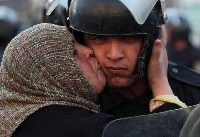 Egyptian woman kissing police officer