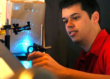 Graduate student Judson Ryckman demonstrating how one of the biosensors works that was made by the direct imprinting of porous substrates process. (Anne Raynor / Vanderbilt University)