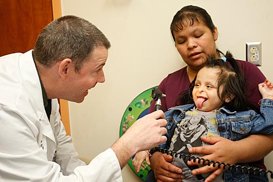 Thomas Morgan, M.D., a clinical geneticist in the Department of Pediatrics at Vanderbilt, examines patient Marieuz Tomas-Francisco, who has an inborn error of metabolism, while her mother, Alicia Francisco Diego holds her. (Daniel Dubois / Vanderbilt University)