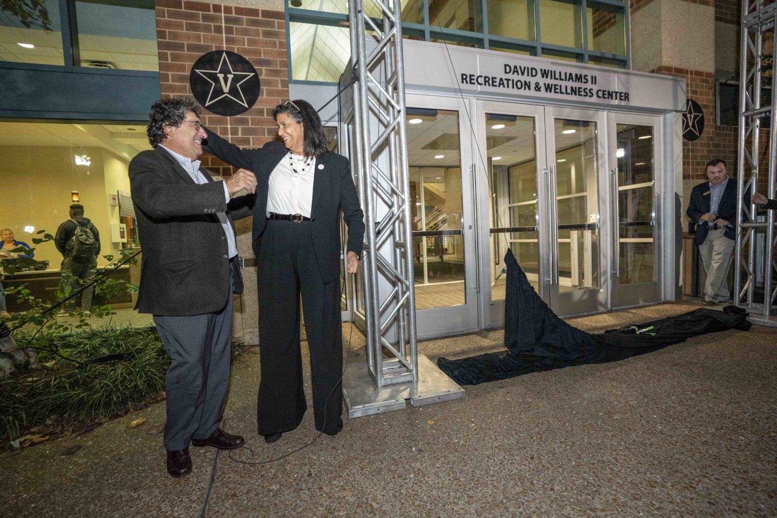 Chancellor Emeritus Nicholas S. Zeppos and Gail Williams next to new signage at the front of the David Williams II Recreation and Wellness Center. (John Russell/Vanderbilt University)