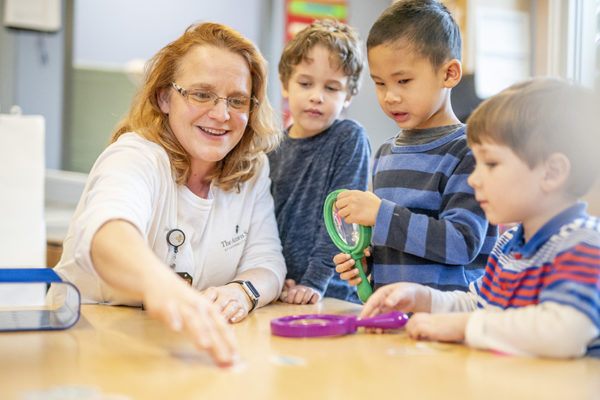 Marybeth Briney, an early childhood educator at The Acorn School, and her students. (John Russell/Vanderbilt)